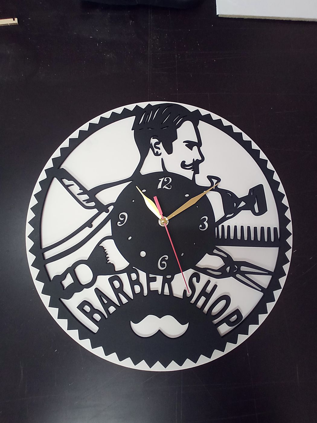Часы Barber Shop на тёмной стене: контрастный светлый рисунок и надпись