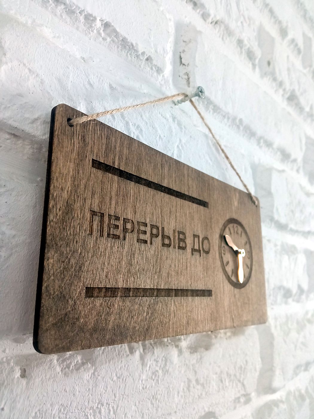 Табличка «Перерыв до» из тонированной фанеры на белой кирпичной стене